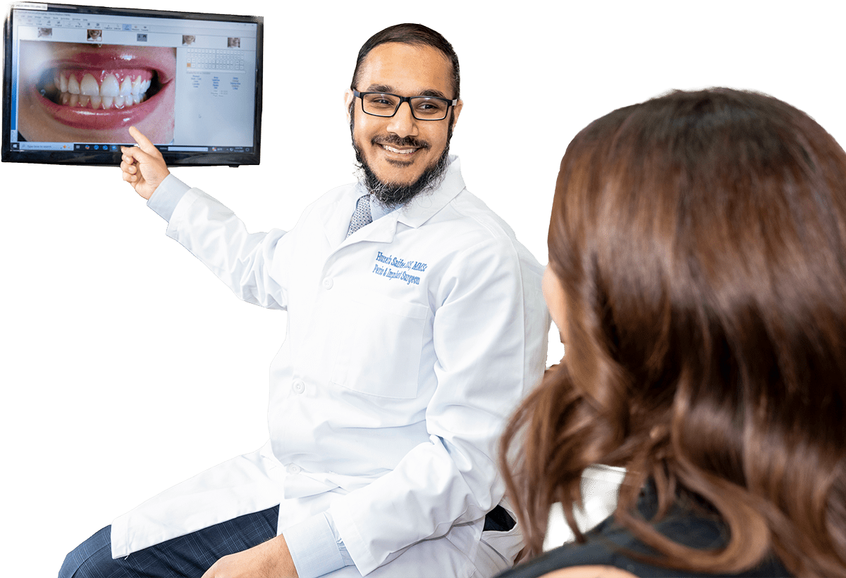 Dr. Saifee showing a patient photos of teeth on a computer